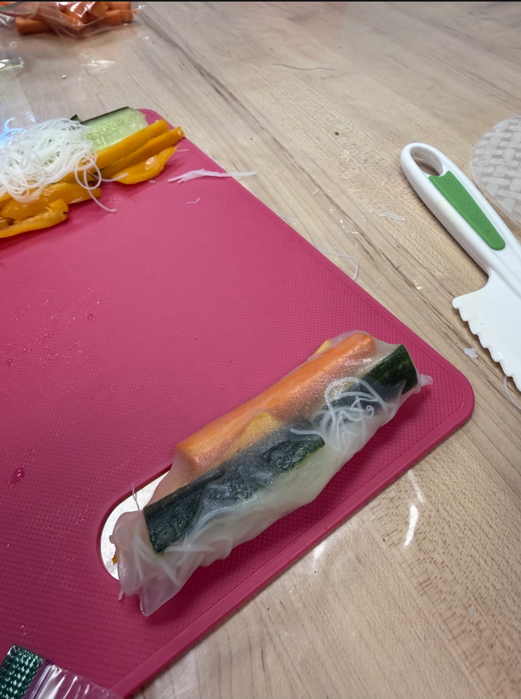 A fresh spring roll assembled with cucumber, carrot, bell pepper, and rice noodles